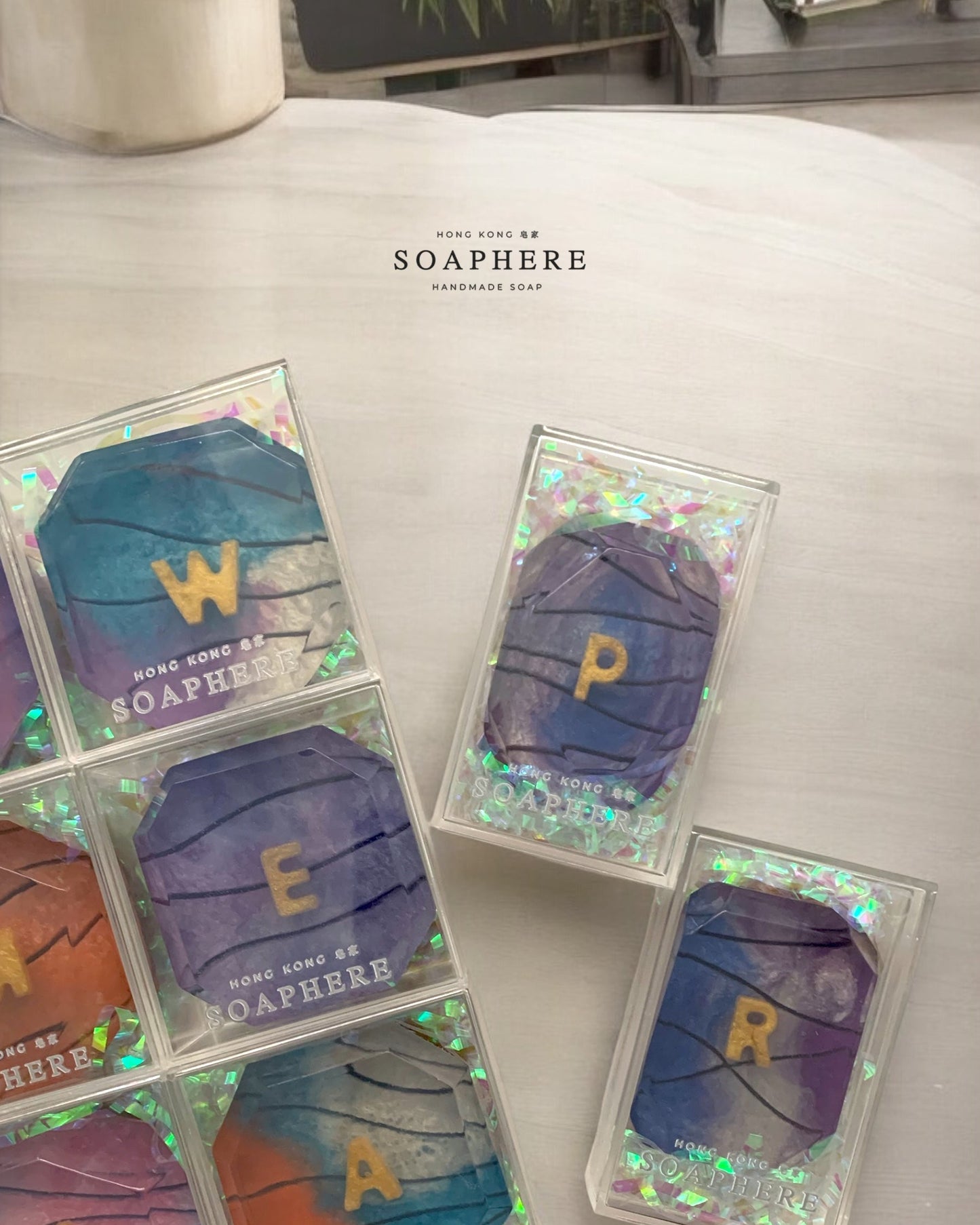 Colorful handmade soap with letters on a light surface.