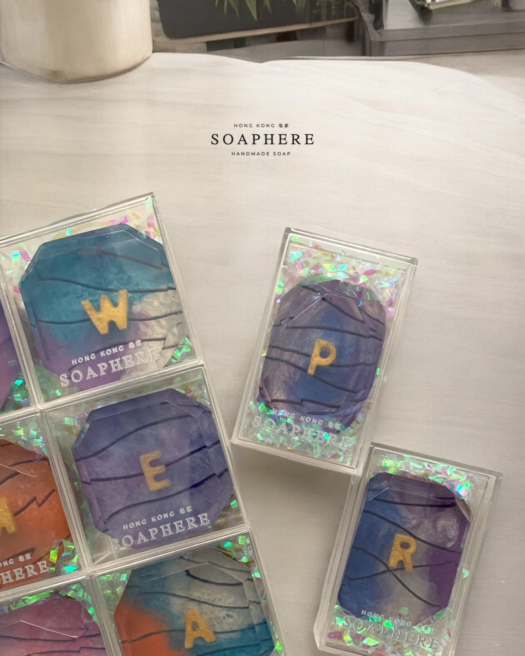 Colorful handmade soap with letters on a light surface.