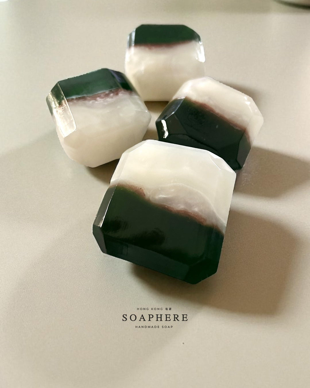 Four hexagonal soap bars with green and white marbled pattern.