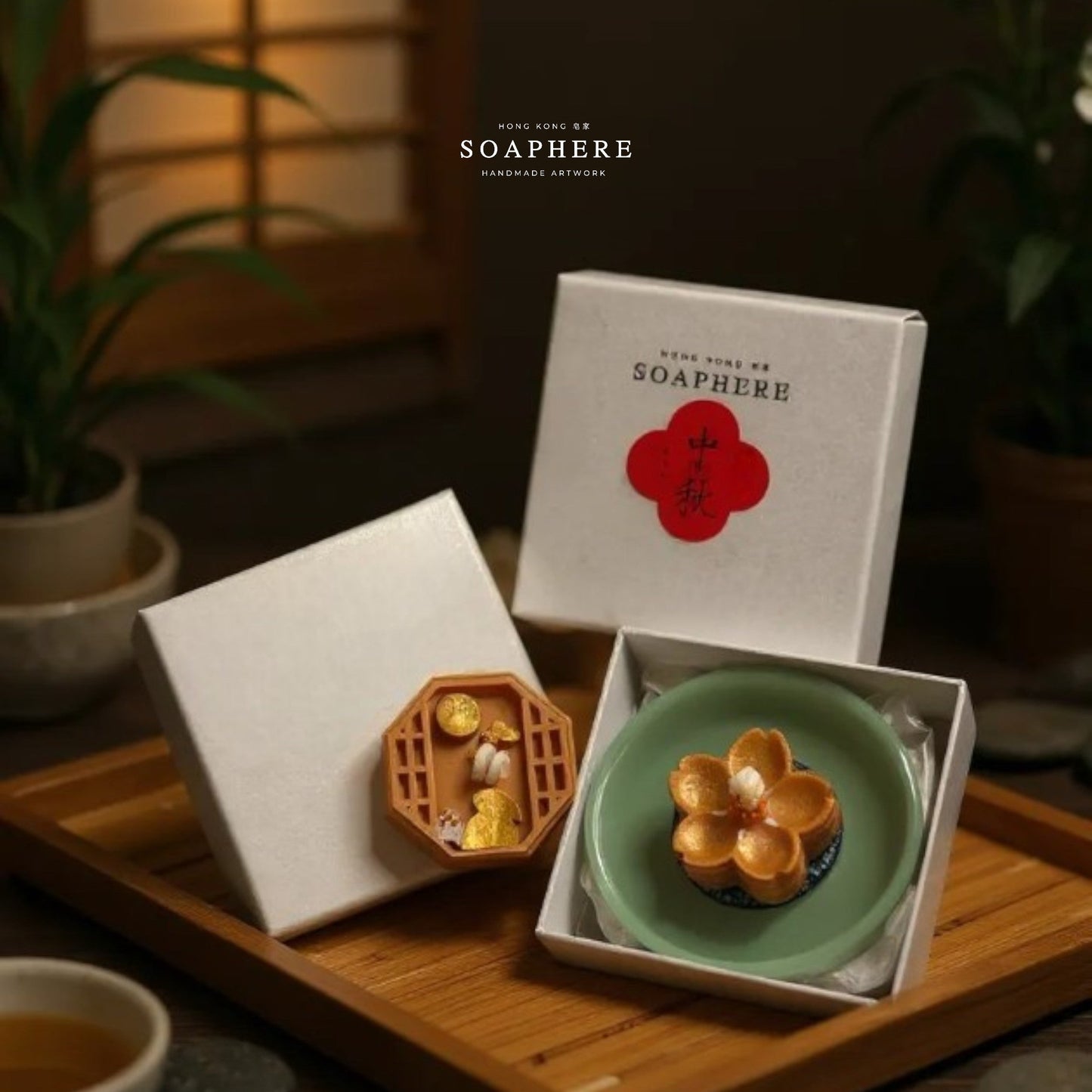 Two mooncake candles in decorative boxes on a wooden tray